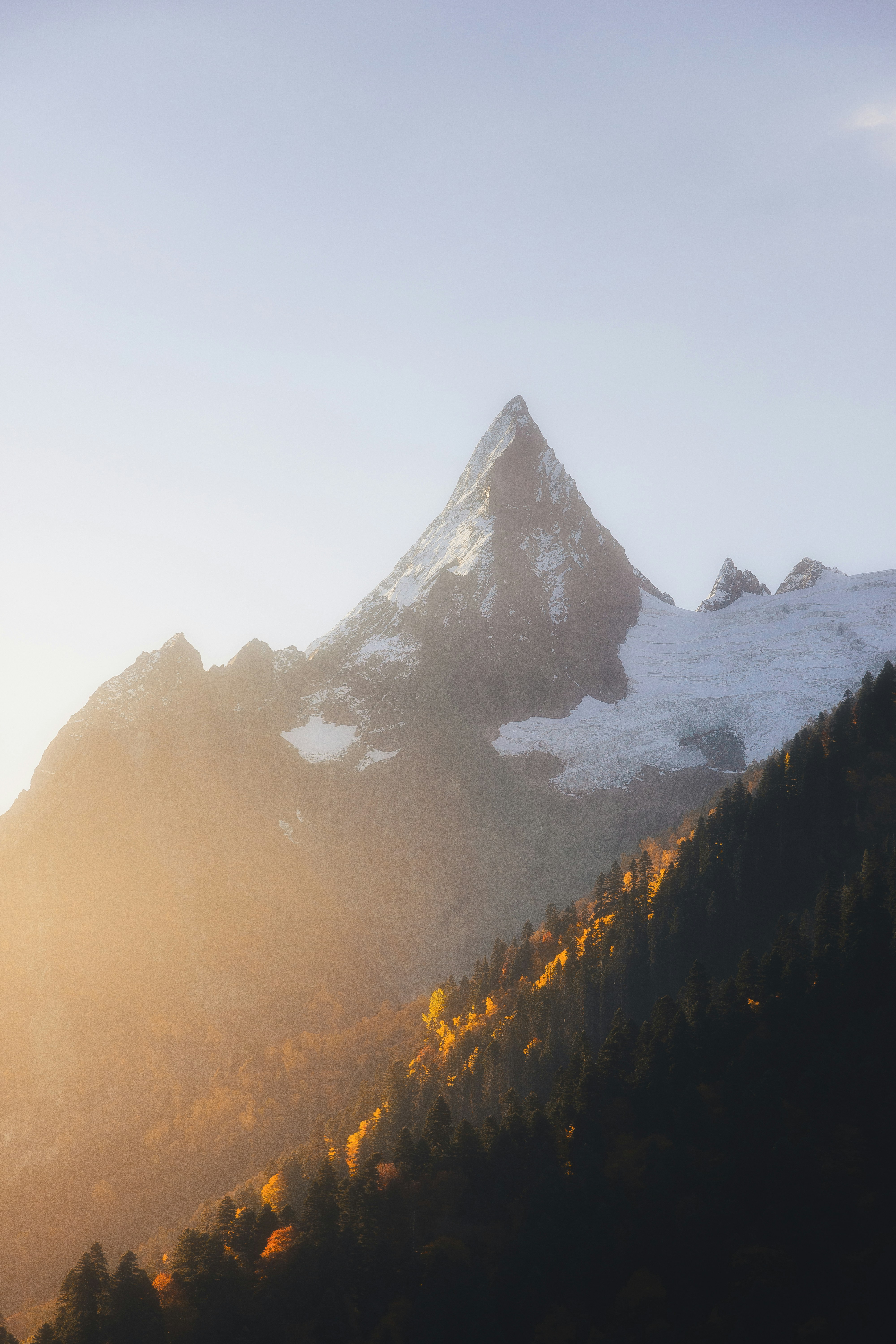Um majestoso pico de montanha coberto de neve ao nascer do sol.