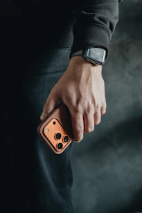 Person holding a smartphone with a camera lens