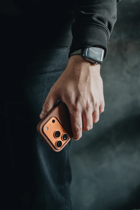 Person holding a smartphone with a camera lens