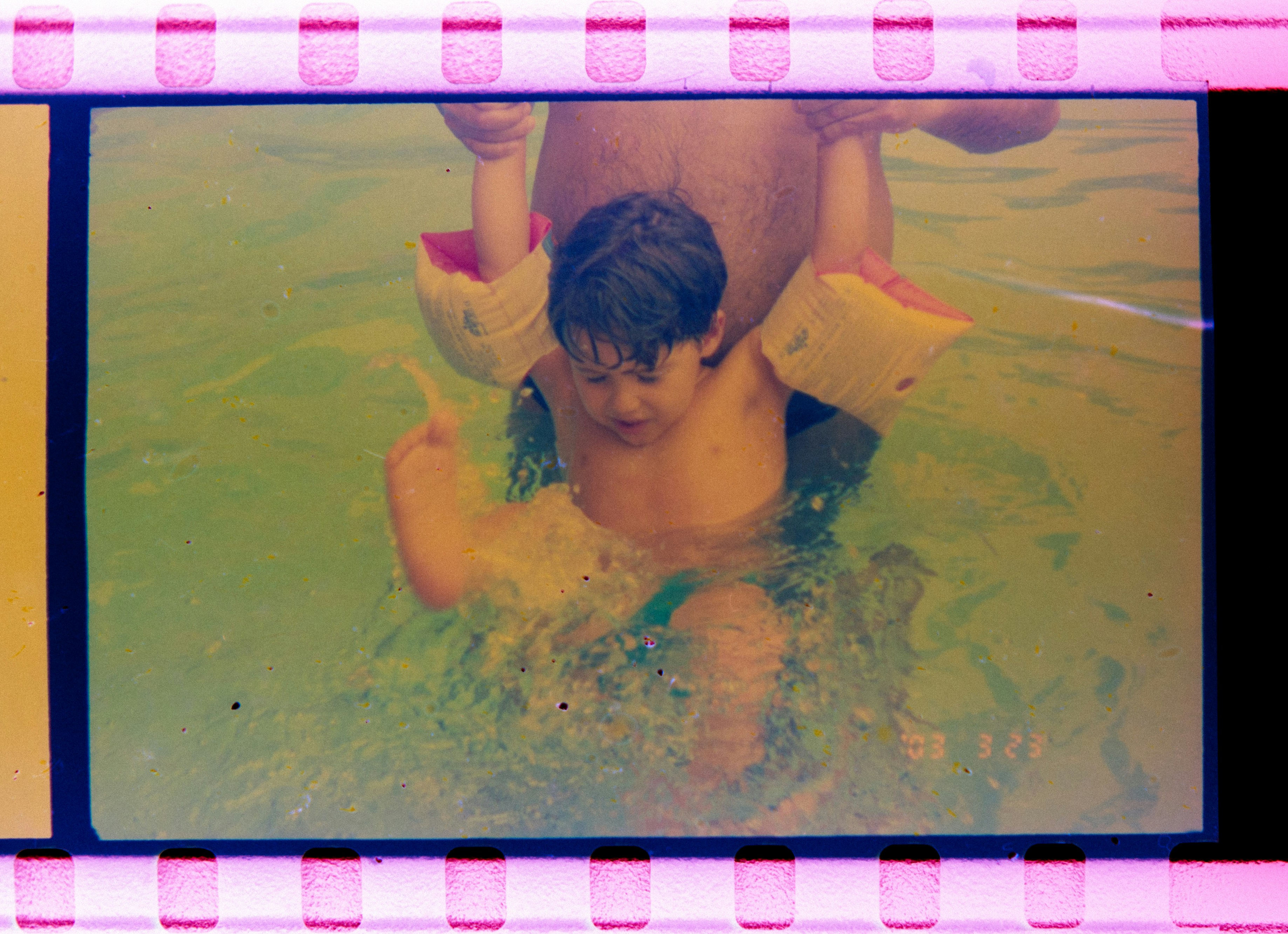 Child with arm floaties in shallow water