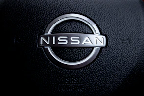 Close-up of a nissan car steering wheel logo.