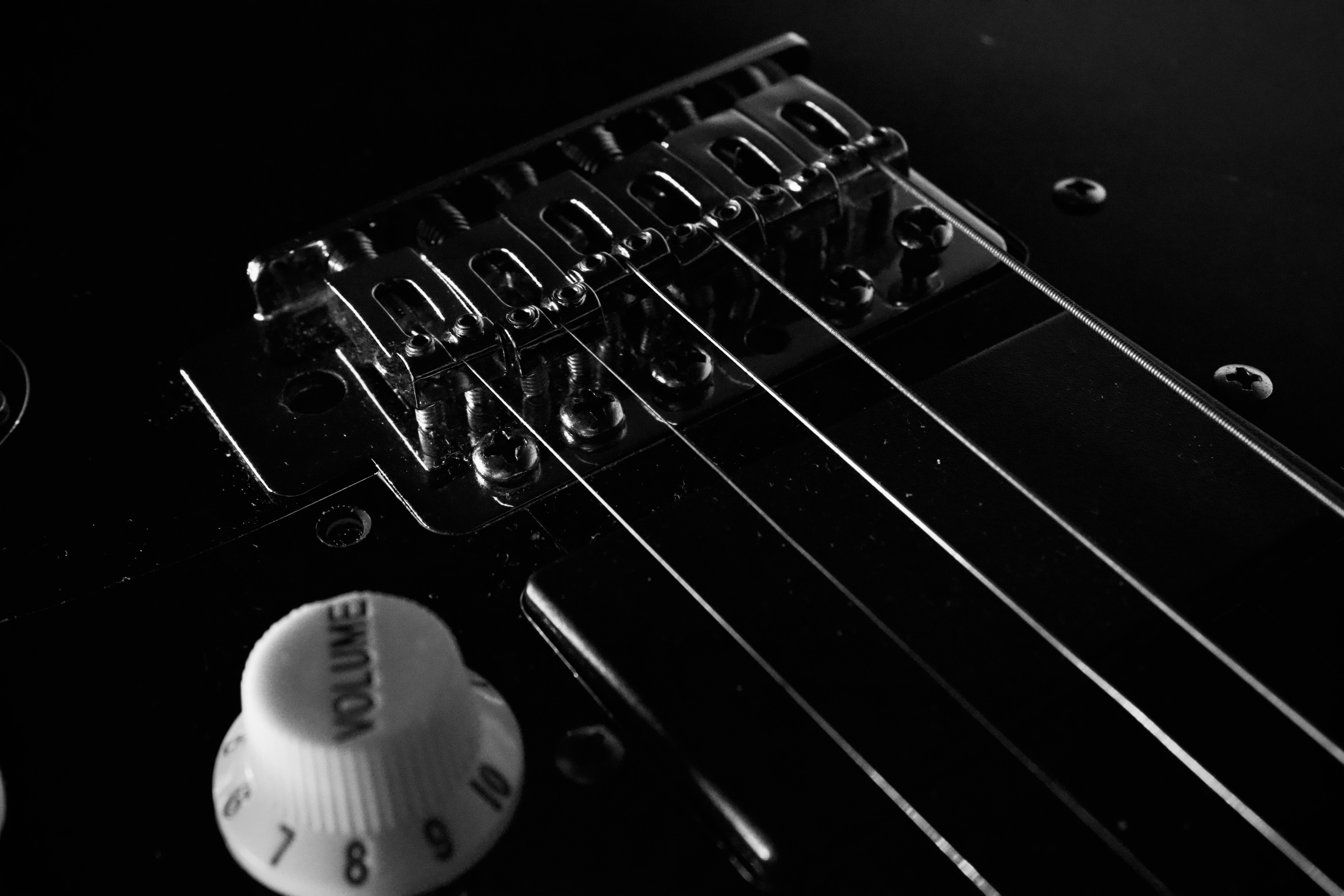 Nahaufnahme der Saiten der E-Gitarre und des Lautstärkereglers