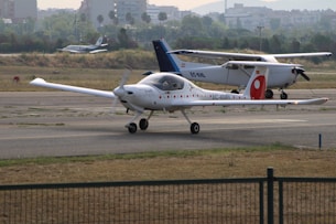 Two small airplanes on an airport tarmac.