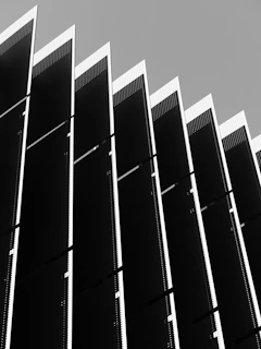 Abstract pattern of dark vertical panels against sky
