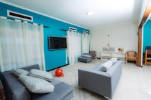 Modern living room with teal walls and gray sofas.