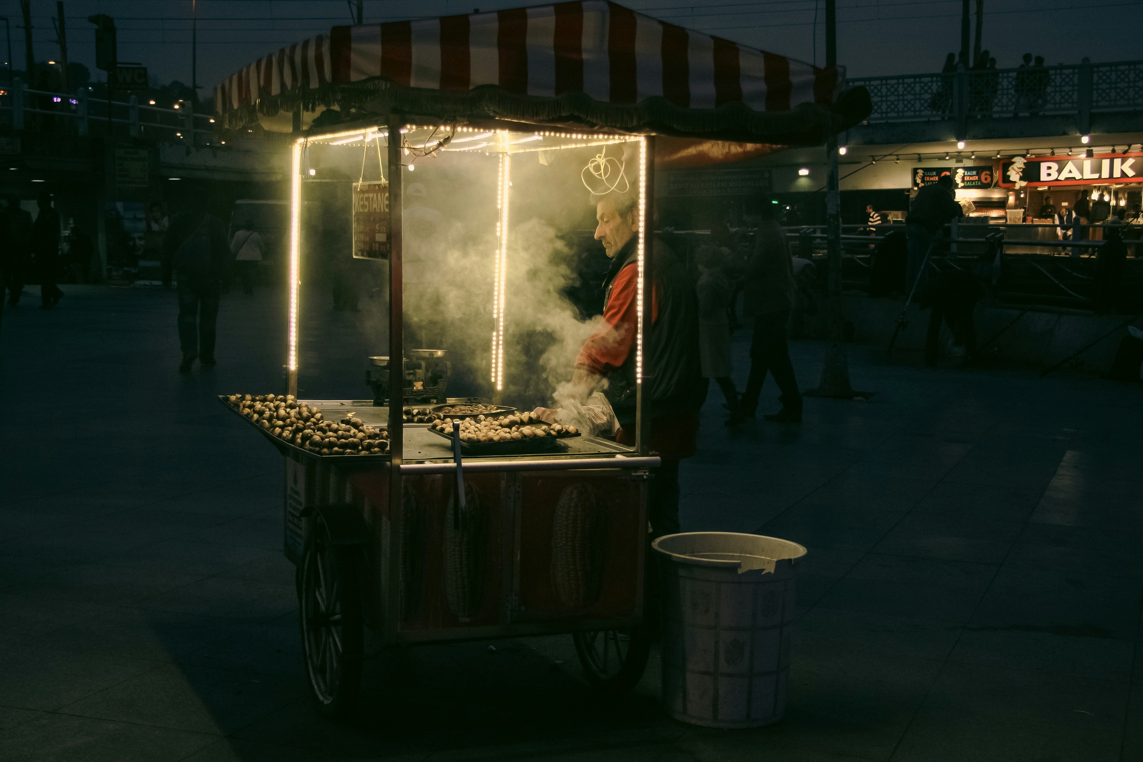 Street vendor roasting chestnuts at night