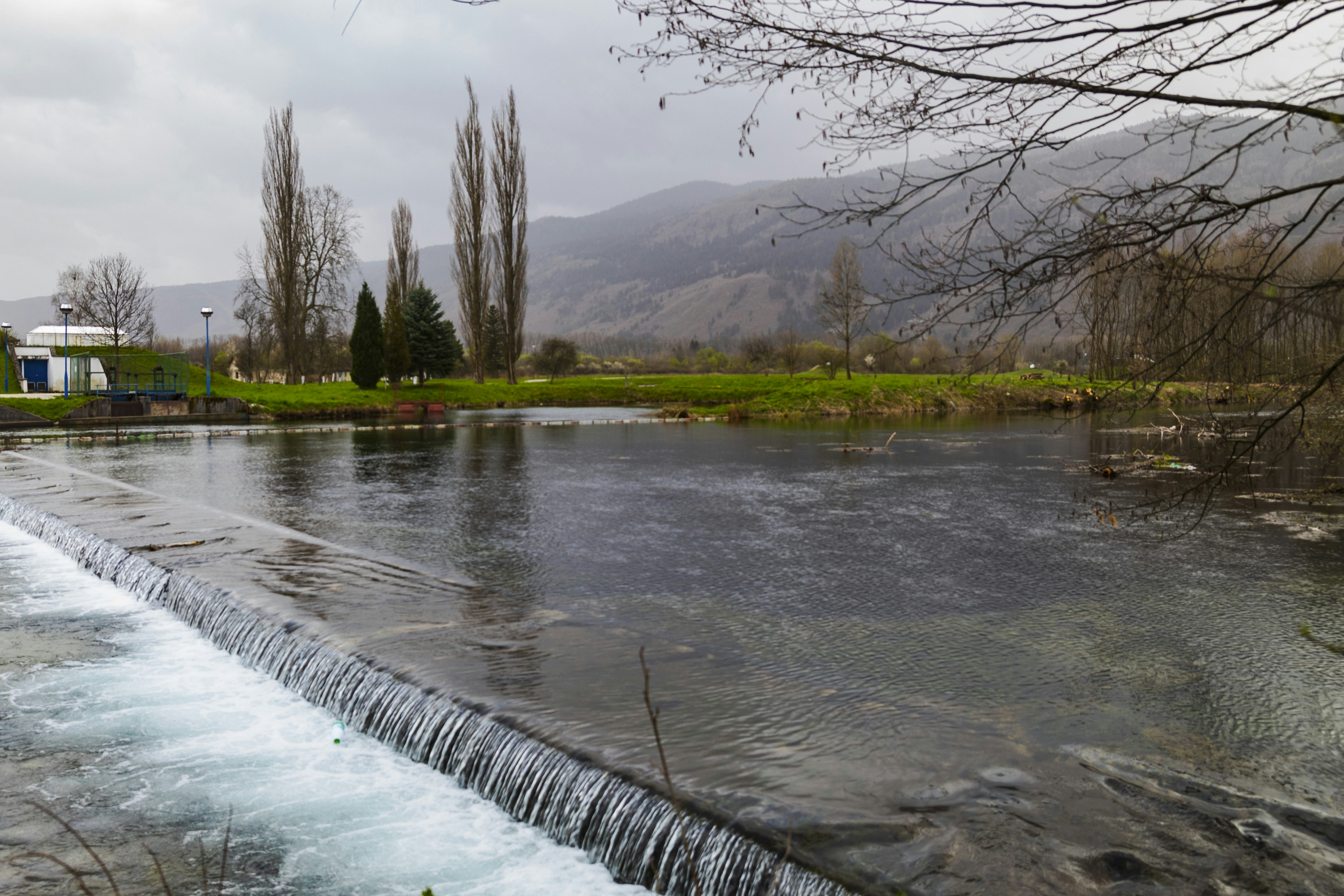 Wide river flows over small dam