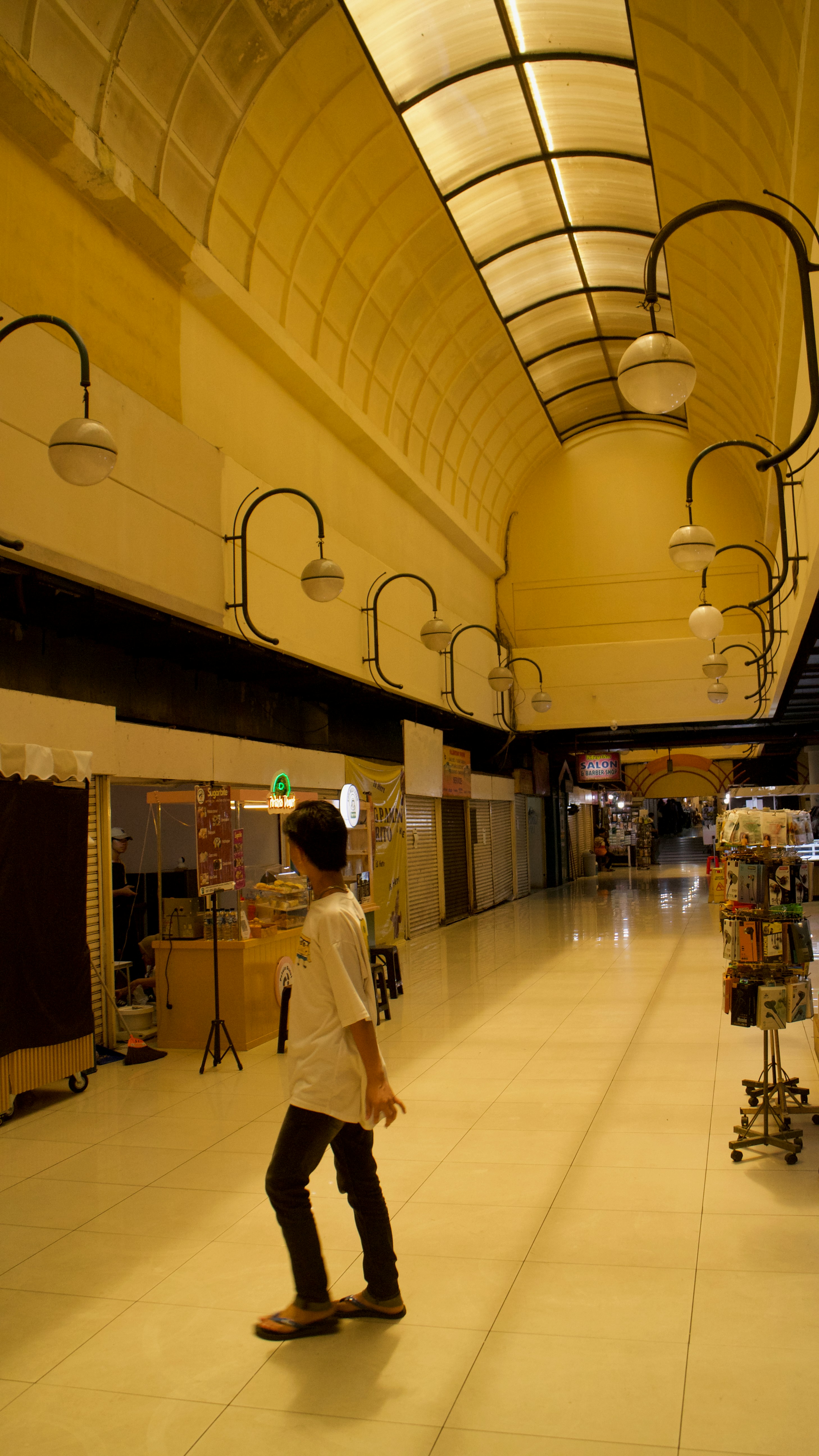 Person walking down a brightly lit indoor hallway.