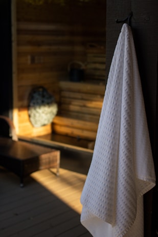 White towel hanging in a warm, wooden sauna.