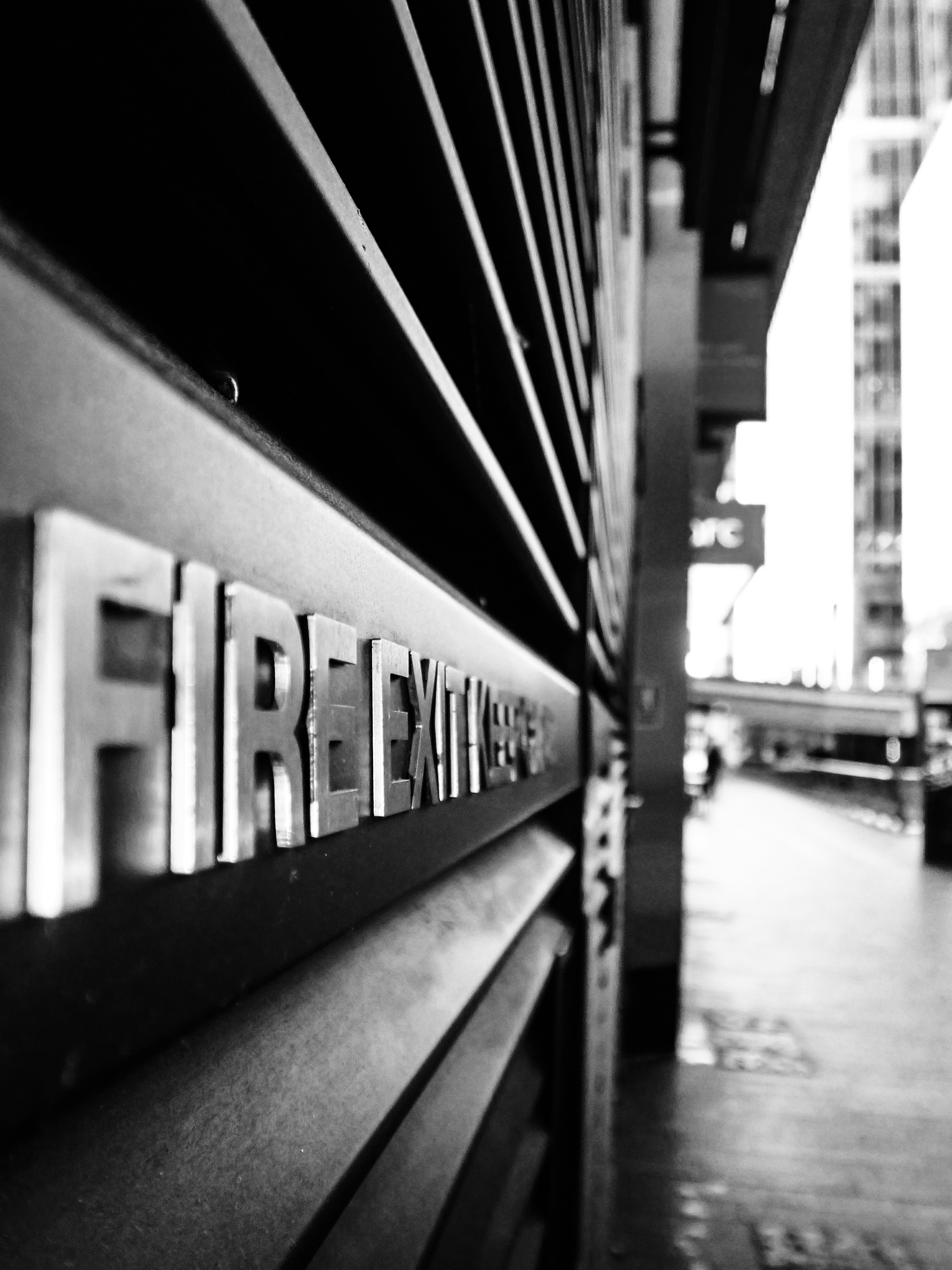 Close-up of a "fire exit" sign on a building.