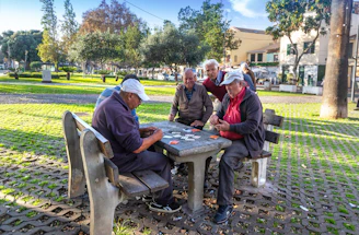 Seniors playing cards at a park table