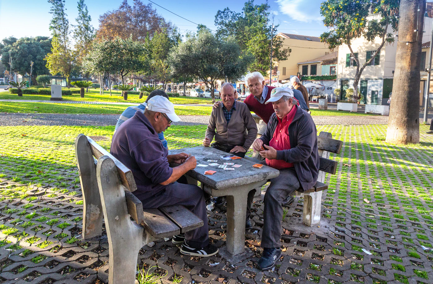 Senior friends enjoying a card game together in the park.