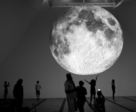 Giant moon installation with people observing