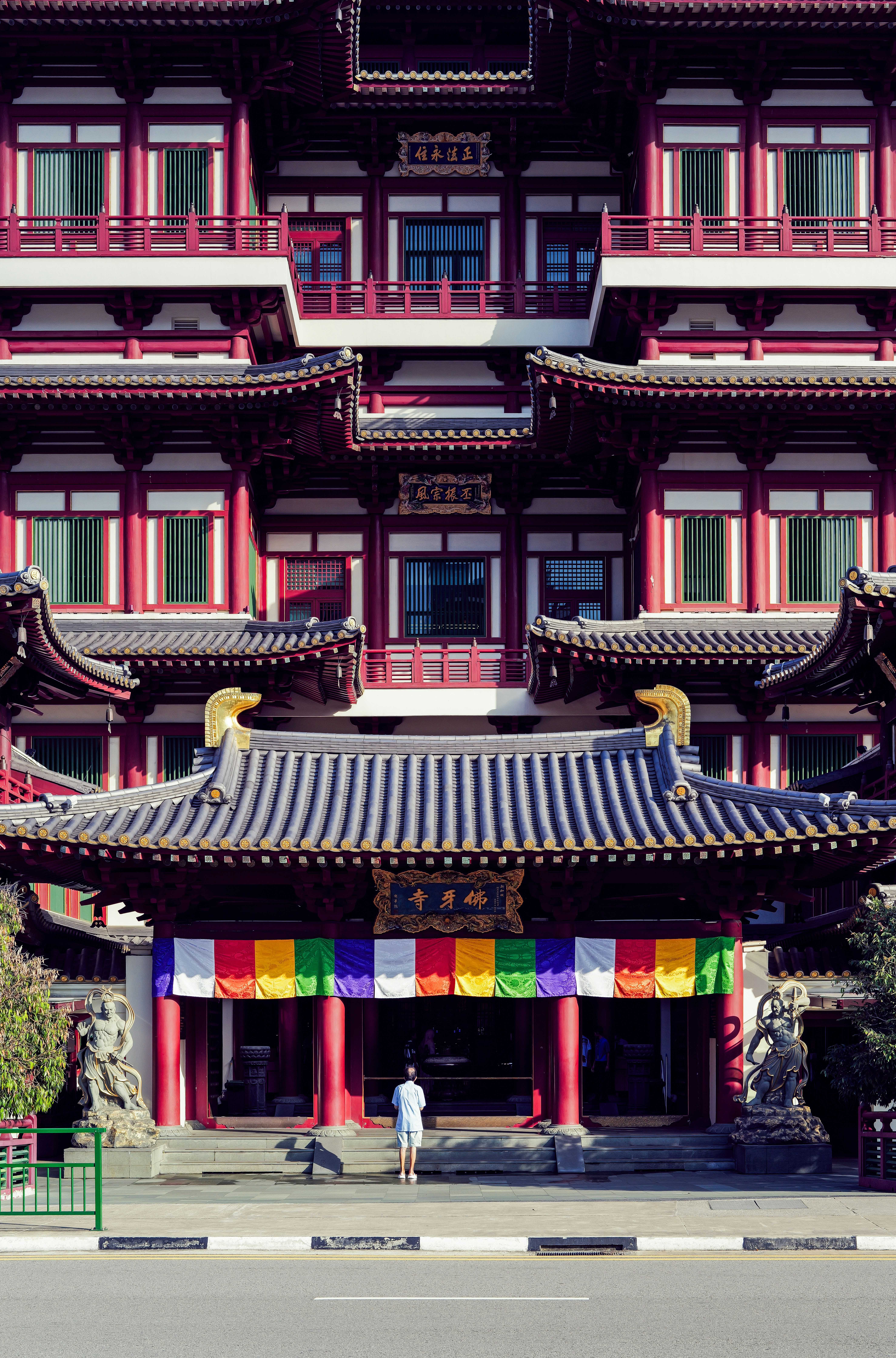 A person stands before a colorful temple entrance.