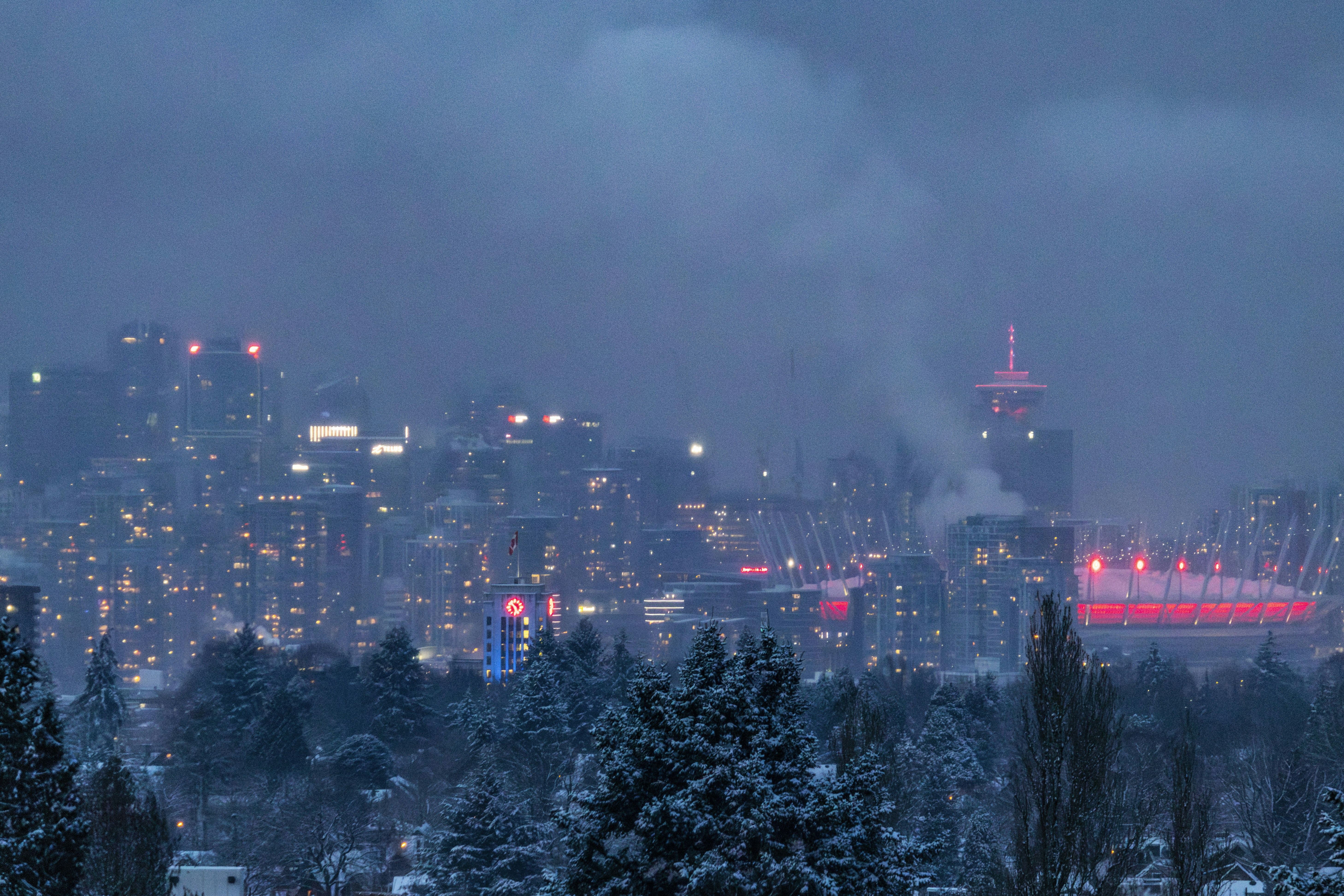 City skyline at dusk with snow on trees