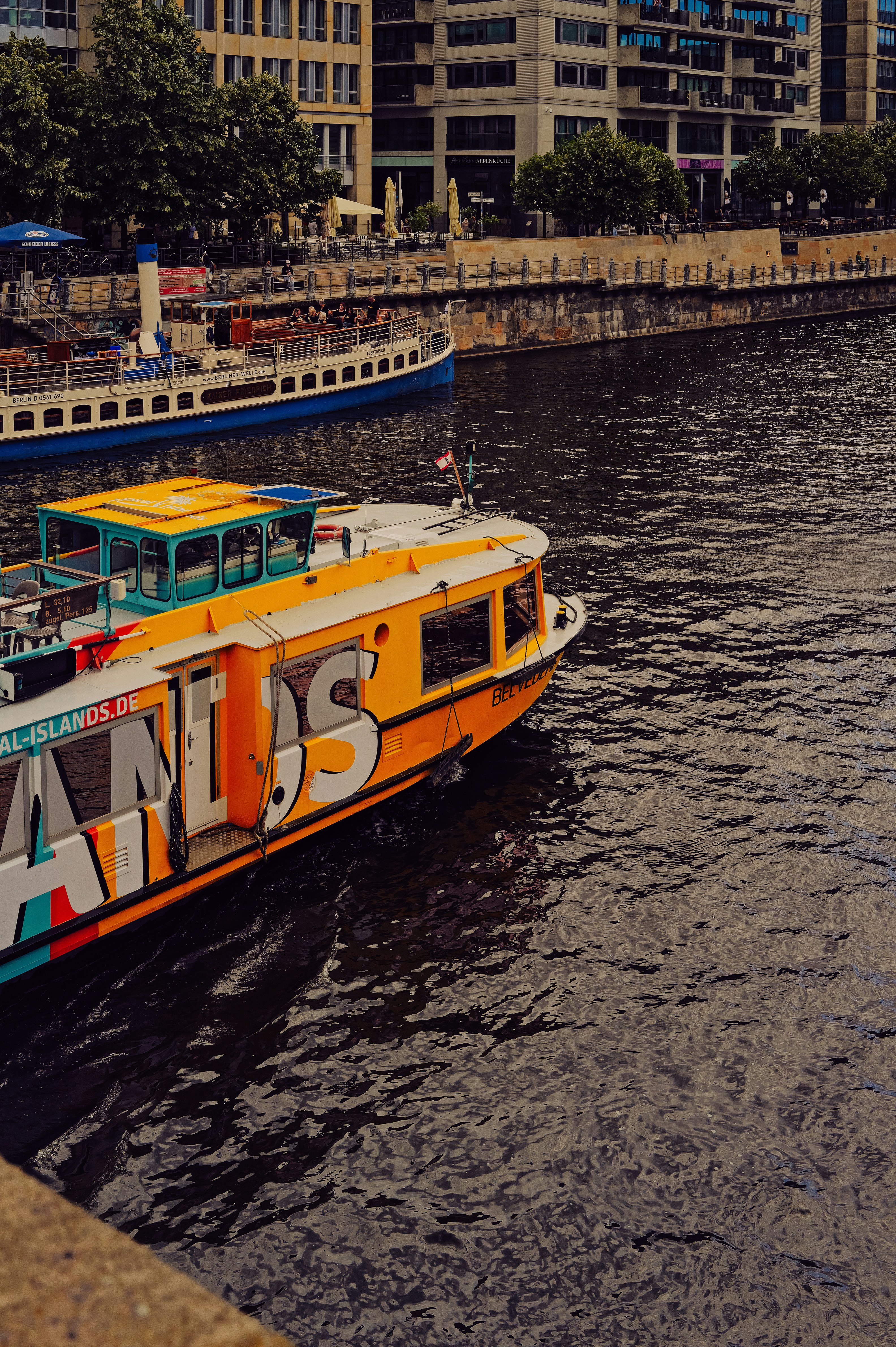 Colorful boat sailing on a dark river.