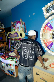 Man playing arcade games in a dimly lit room.