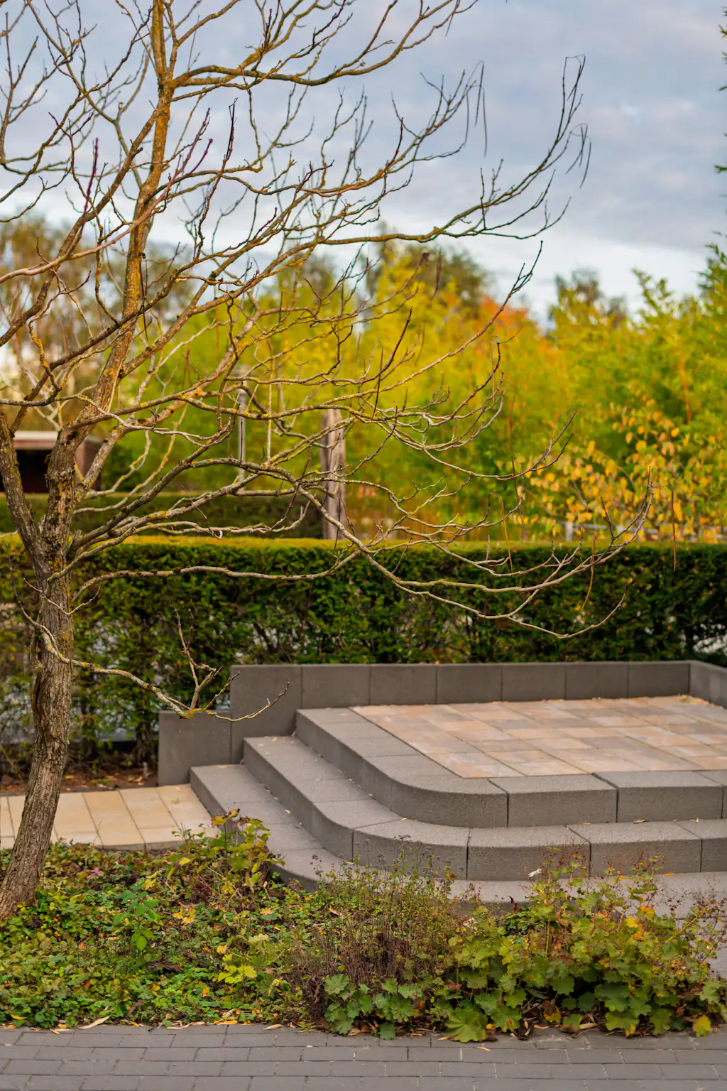 Curved stone steps leading to a paver patio, an example of Ridgeline hardscape work