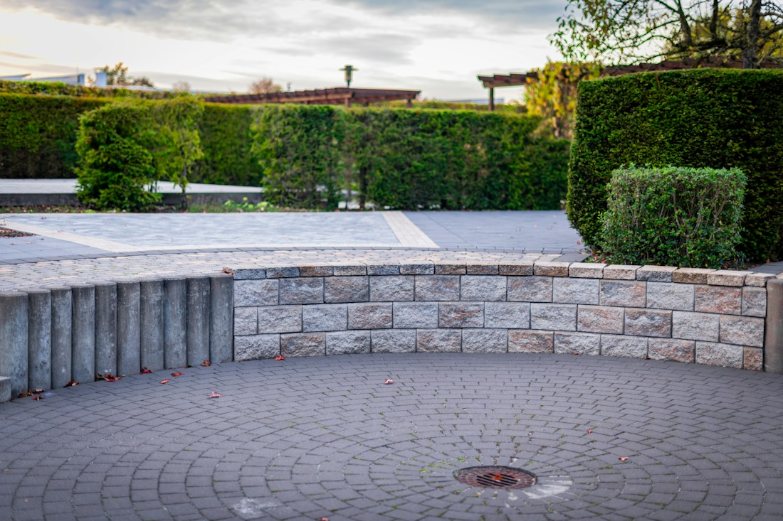 Curved stone wall around a paved circle in winter light