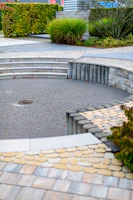 Curved paved seating area with stone steps and greenery