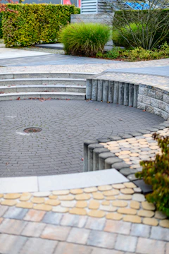 Curved paved seating area with stone steps and greenery