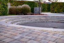 Curved stone steps surround a paved circular area