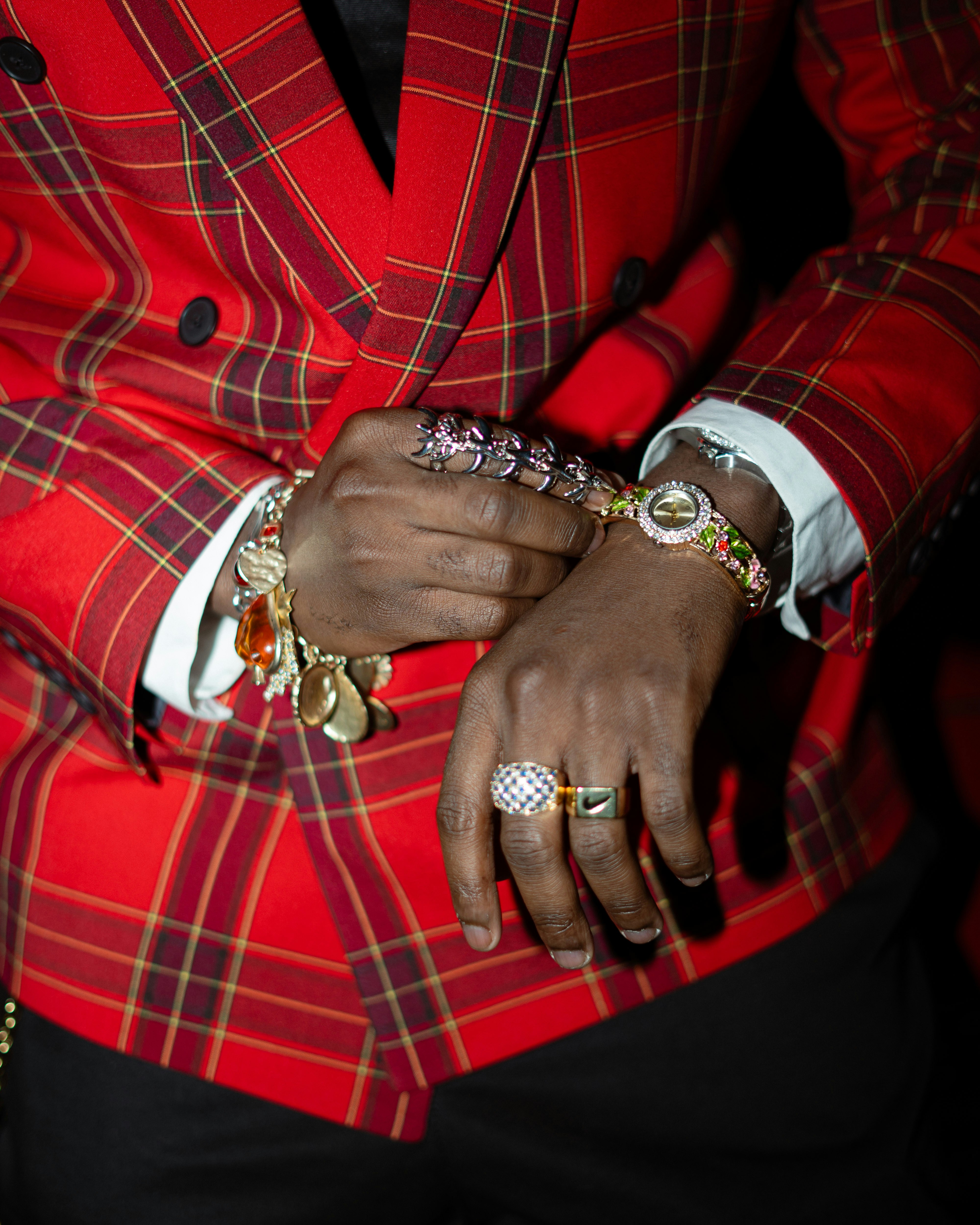 Person wearing a red plaid jacket and many bracelets.