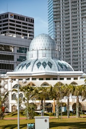 Modern mosque with glass dome surrounded by buildings