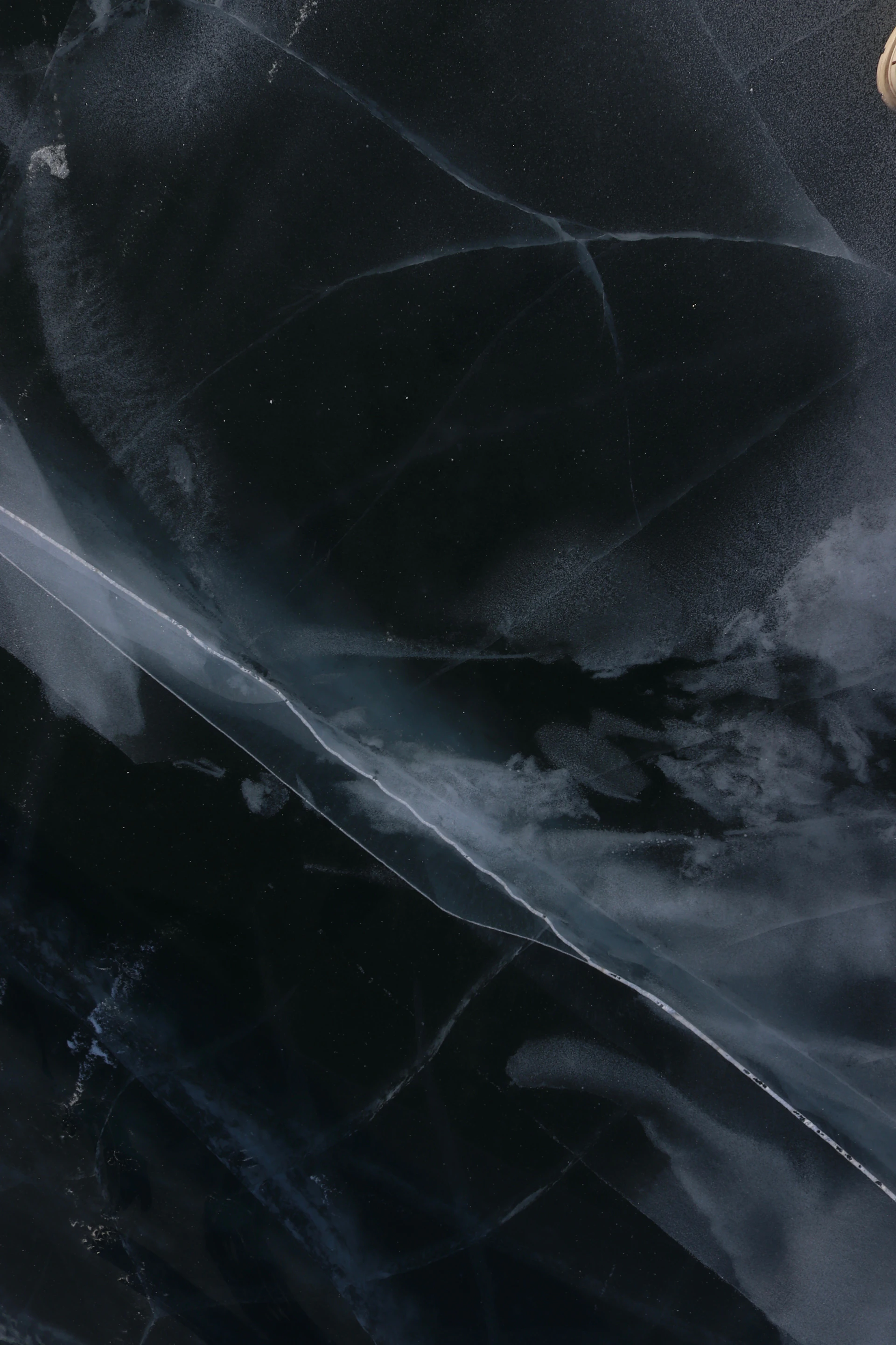 Cracked dark ice surface with white lines