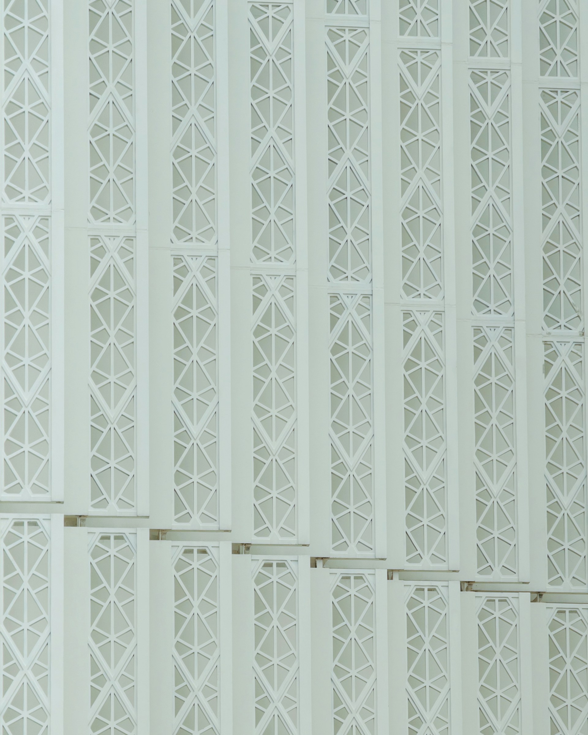 White geometric architectural pattern with repeating vertical lines.