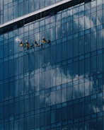 Window cleaners work on a modern glass building