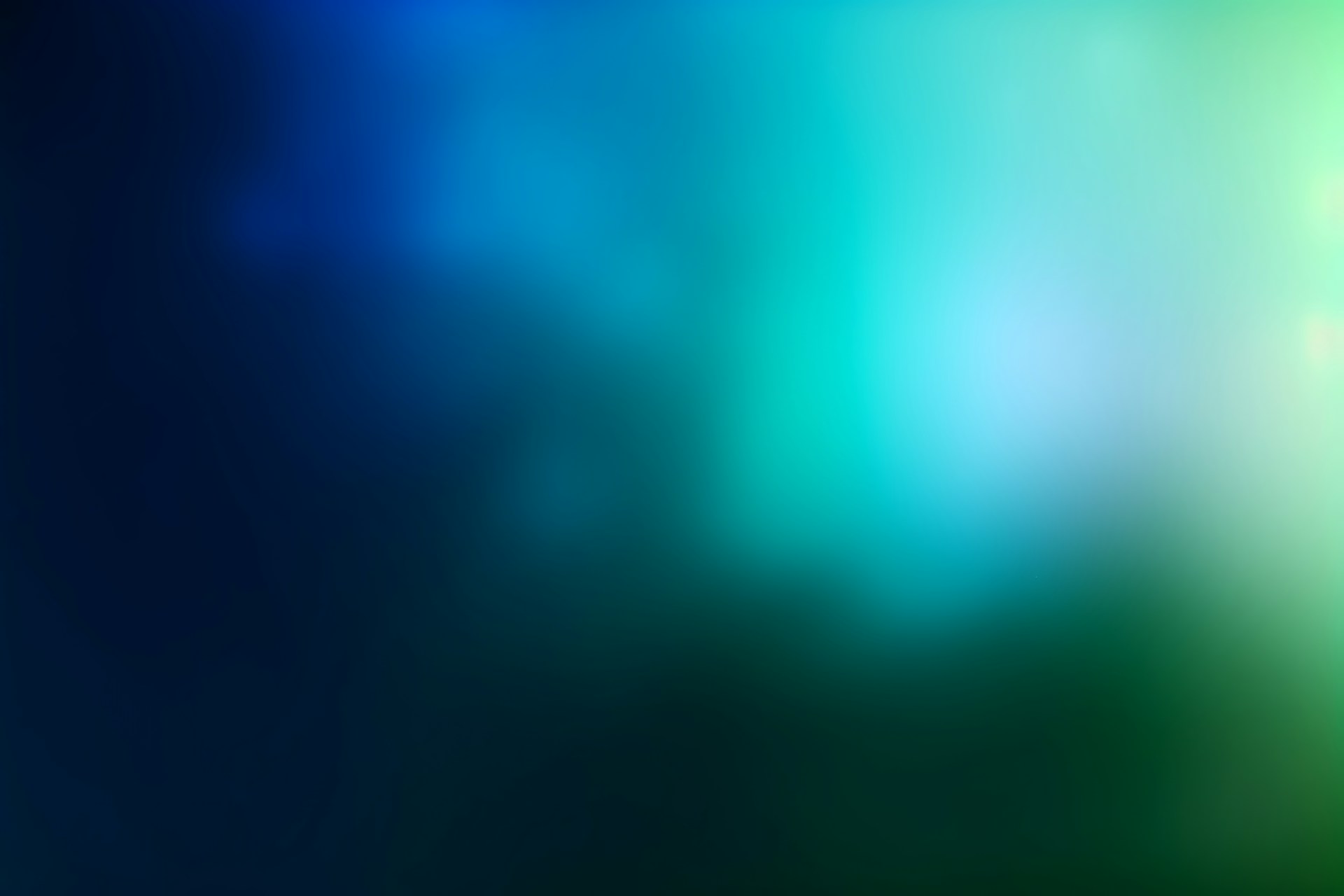 Abstract gradient of blue, green, and white light.