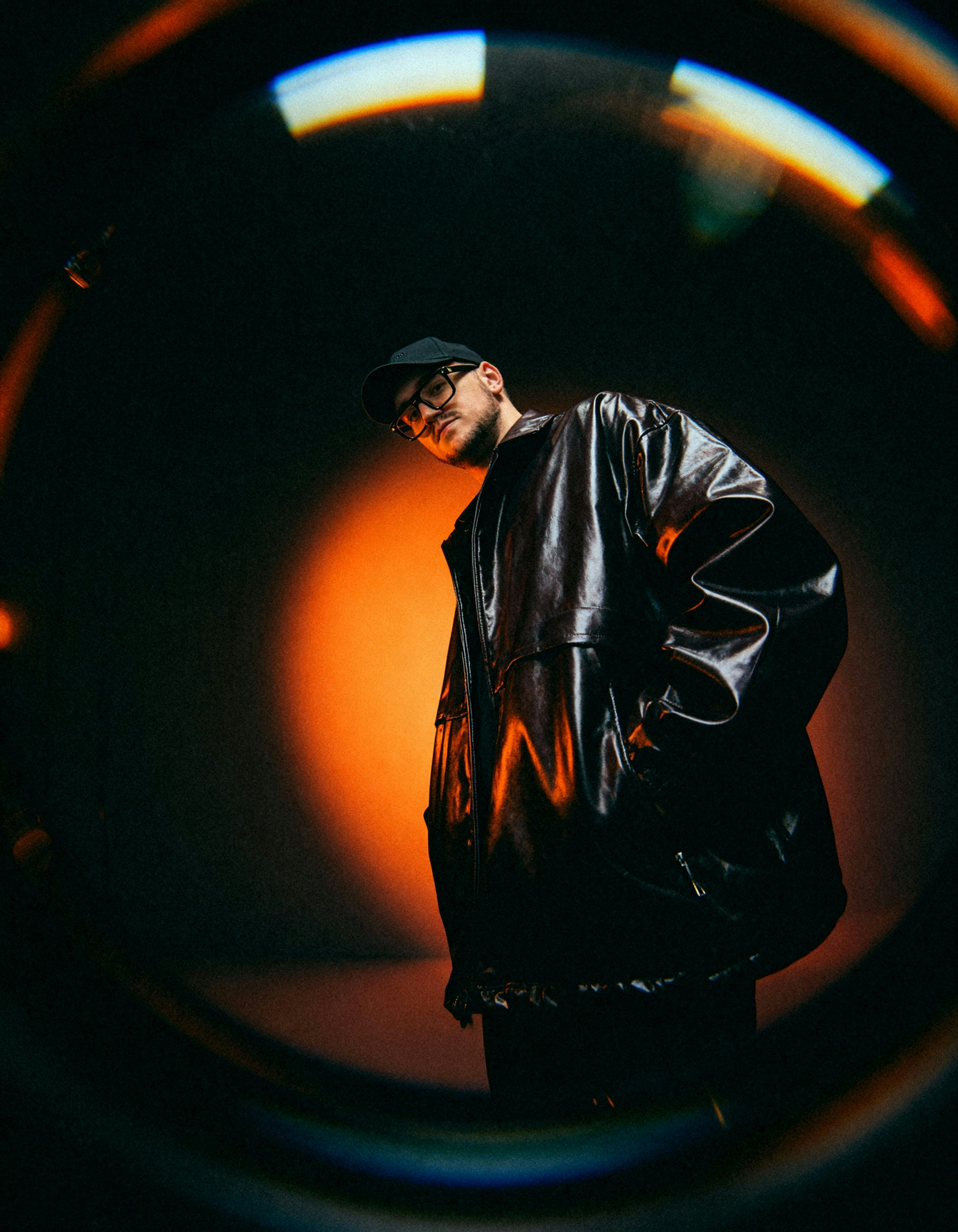 Man in leather jacket and cap with glasses
