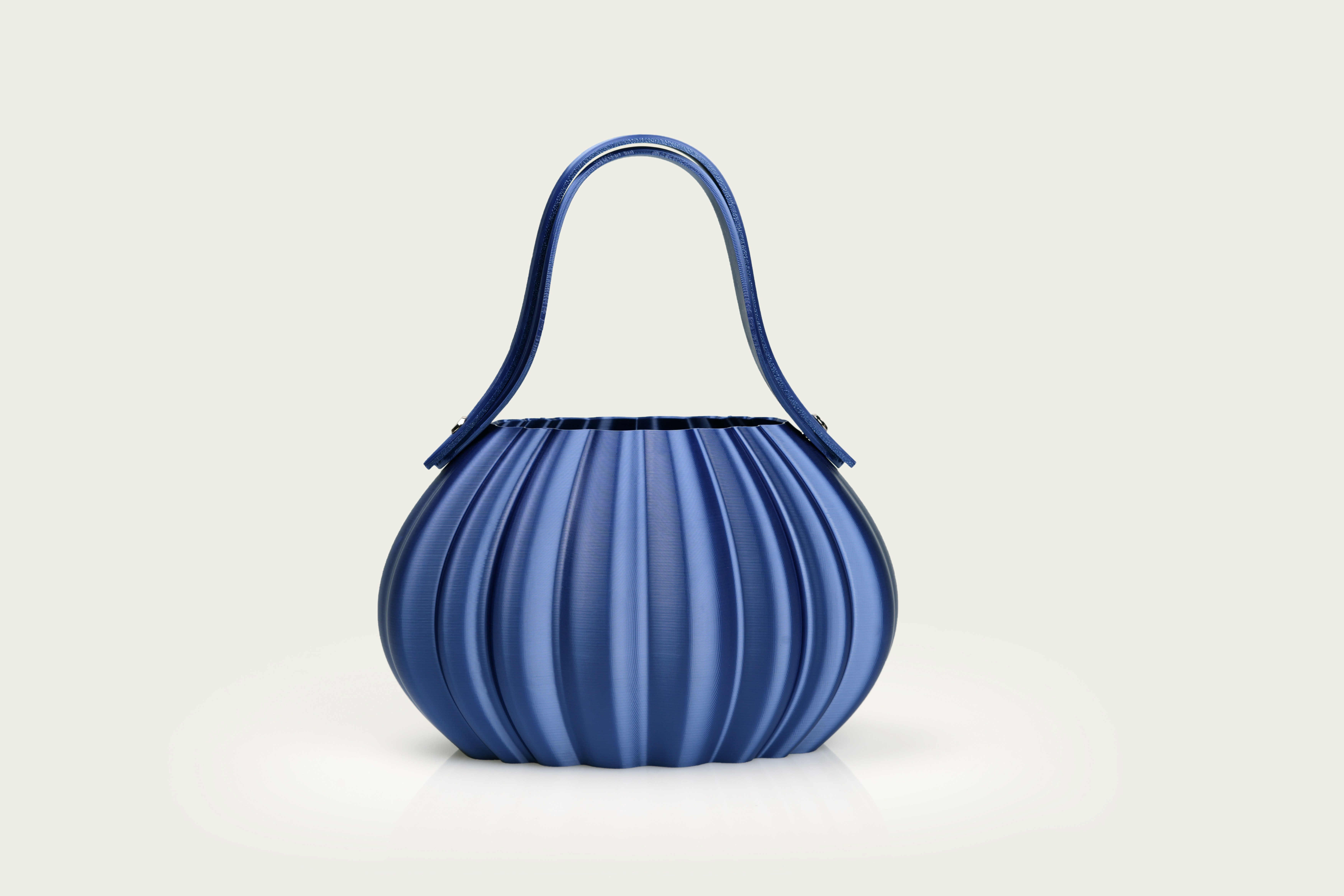 Una borsa plissettata blu con manico curvo.