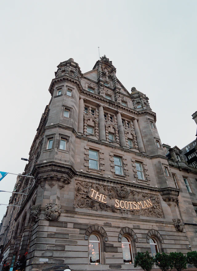The sandstone facade of The Scotsman Hotel with its carved name above the entrance