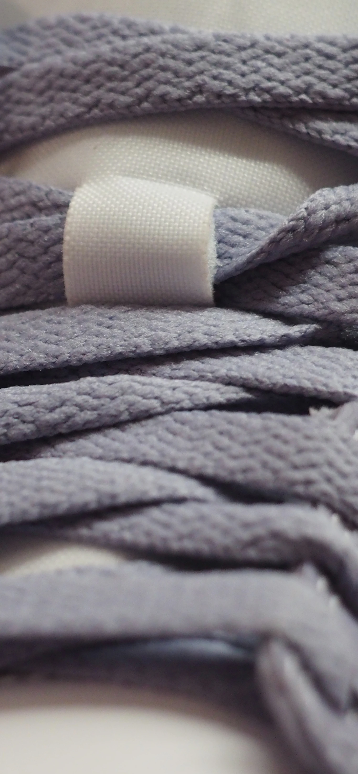 Close-up of lavender flat shoelaces with a white tag