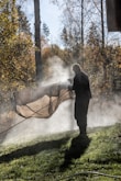 Man spraying water on a tarp outdoors