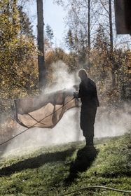 Man spraying water on a tarp outdoors
