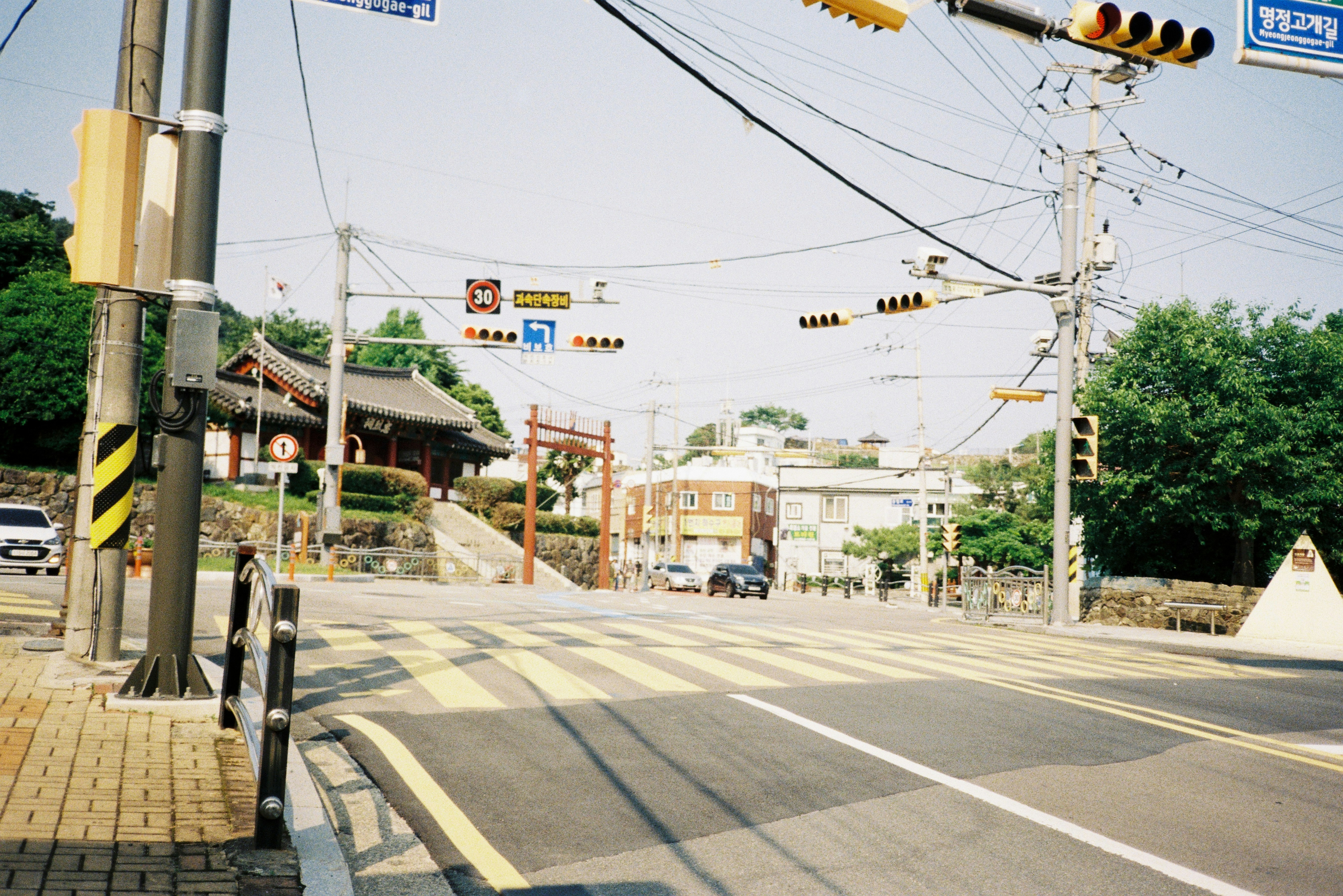 Street intersection with traffic lights and pedestrian crossing.
