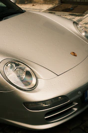Silver porsche car with water droplets