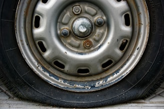 Close-up of a worn car tire and rim.
