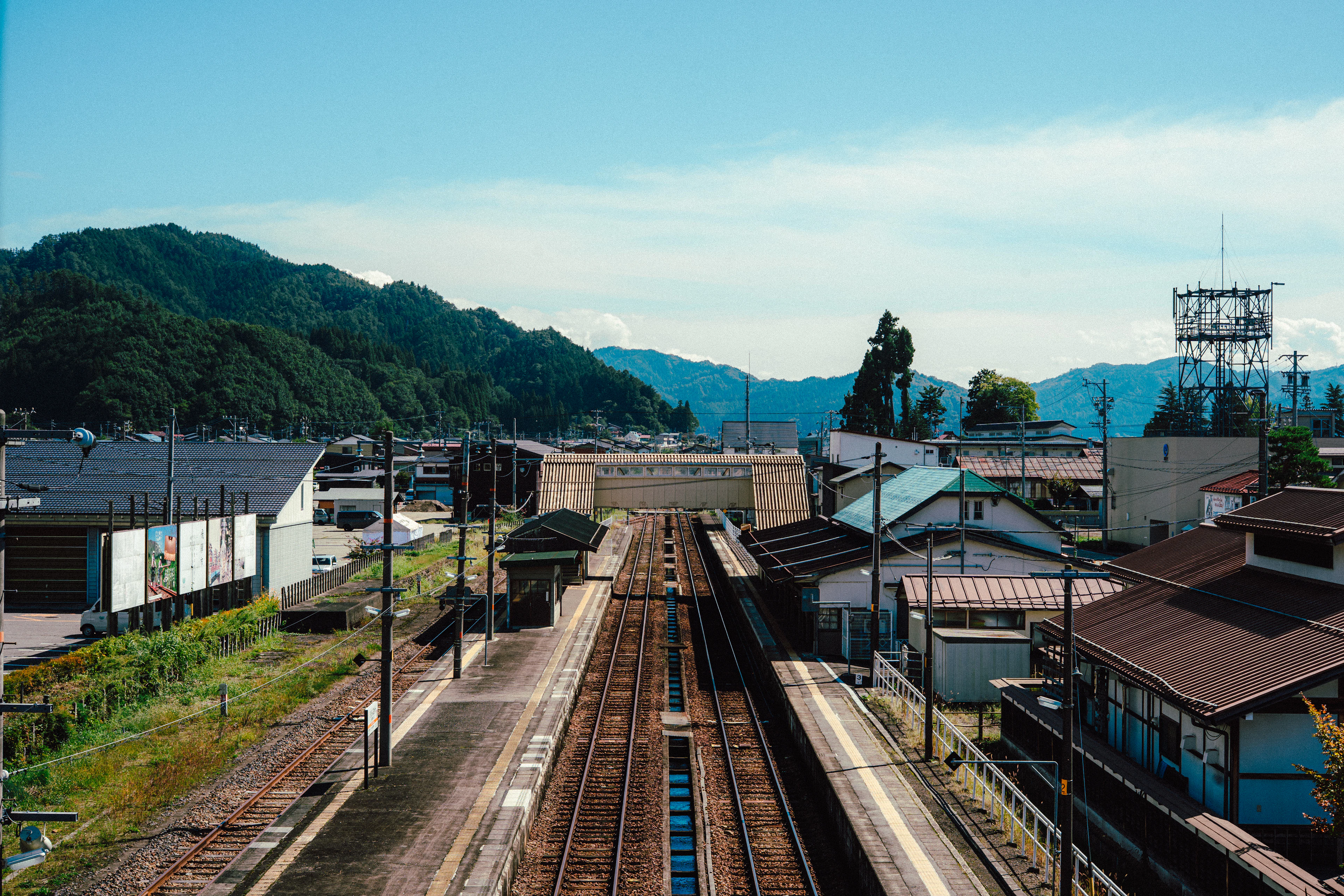 Railway tracks running through a small town between wooded hills, Hida-Furukawa station, Gifu Prefecture, Japan