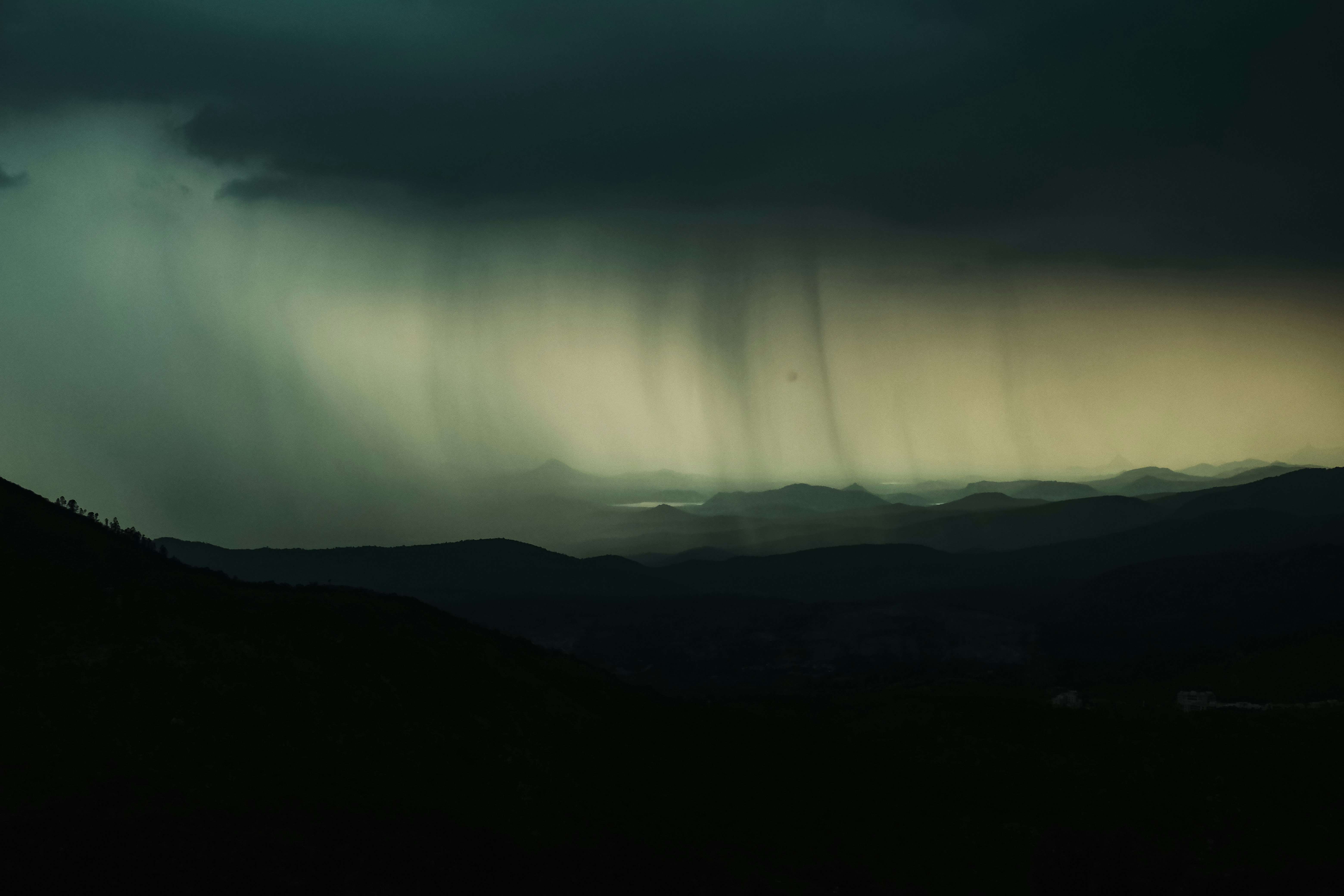 Nuvens escuras de tempestade com chuva sobre montanhas distantes