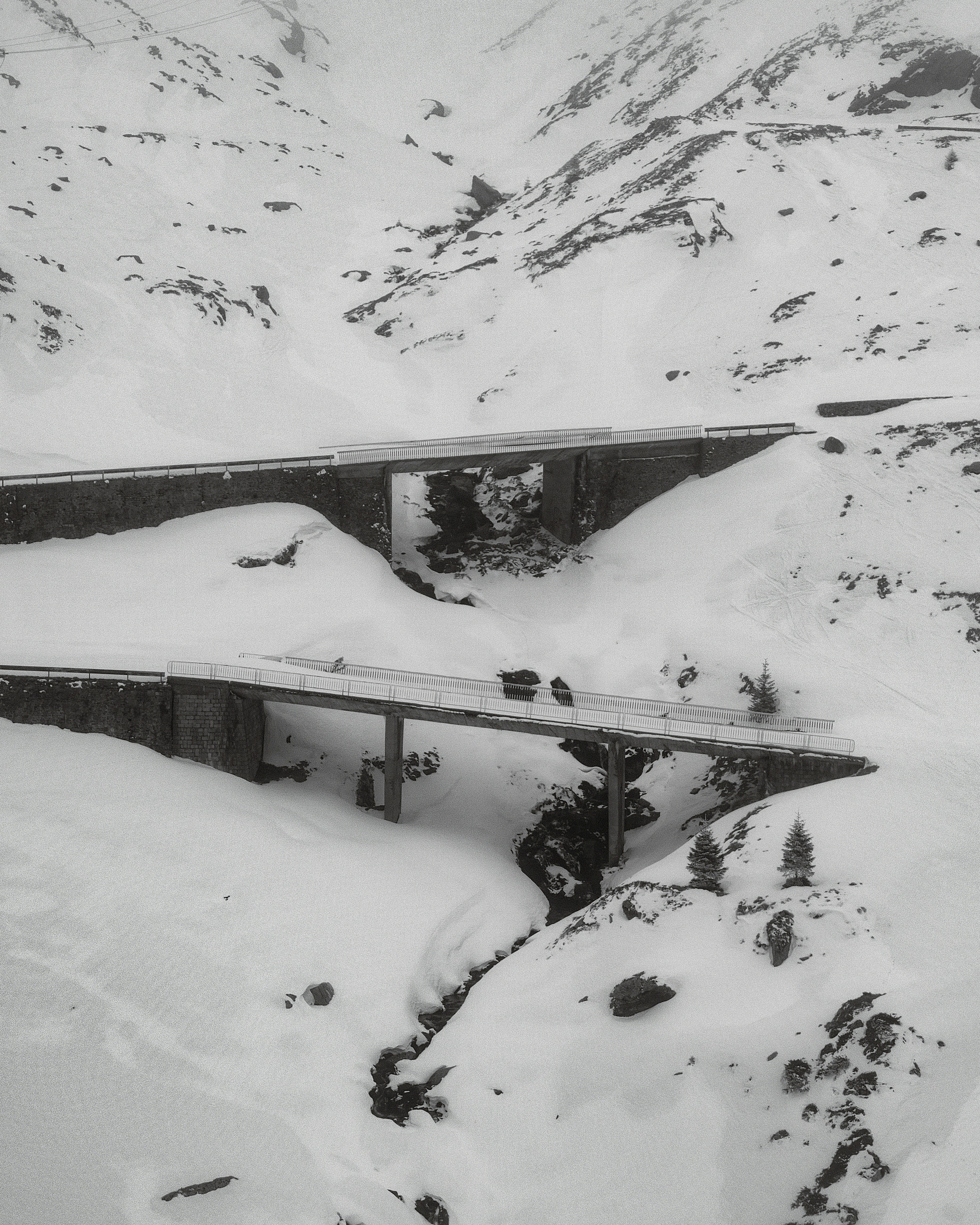 Carros dirigindo em pontes de montanha nevadas no inverno.