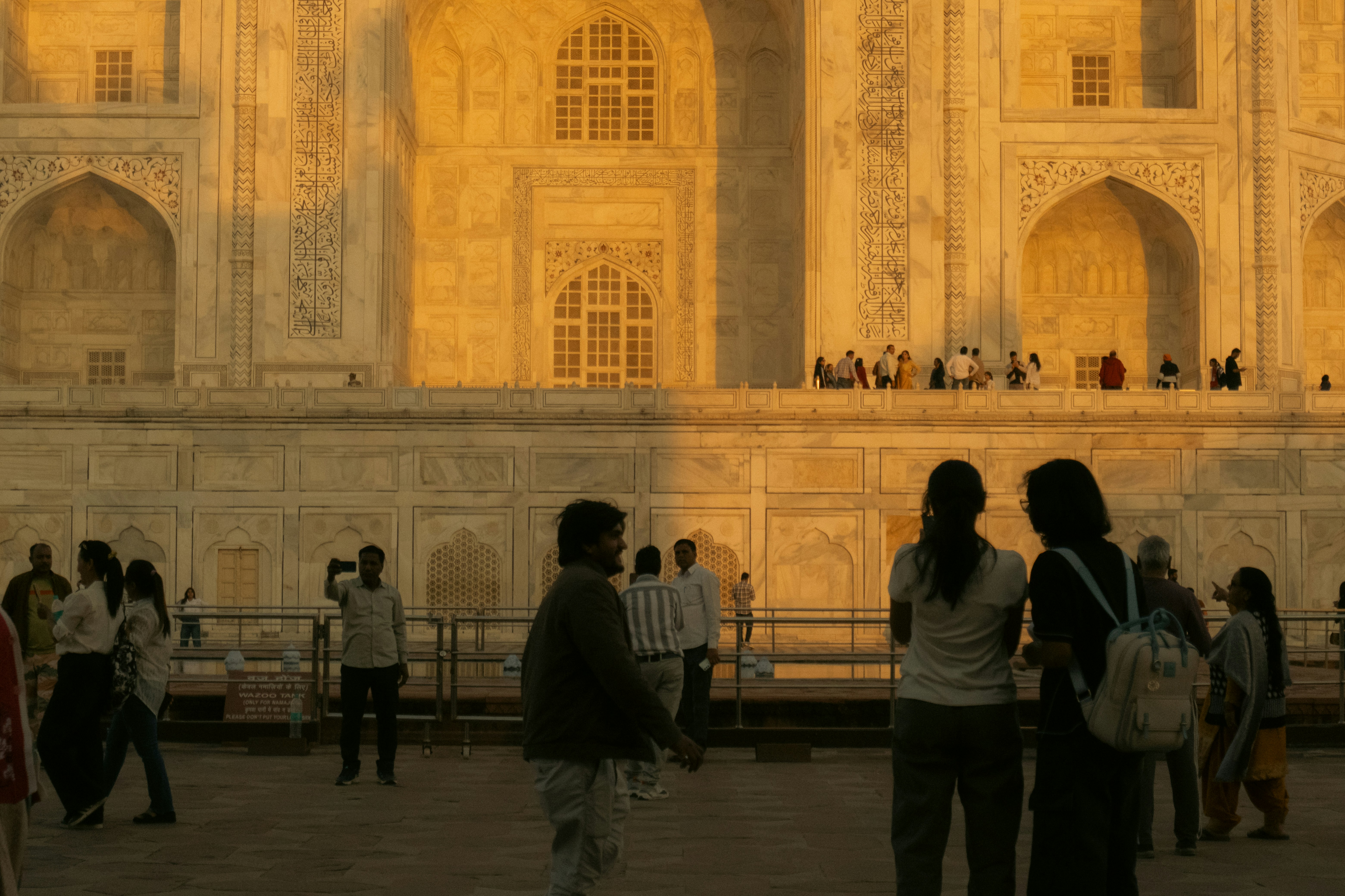 People gather at the taj mahal during sunset.