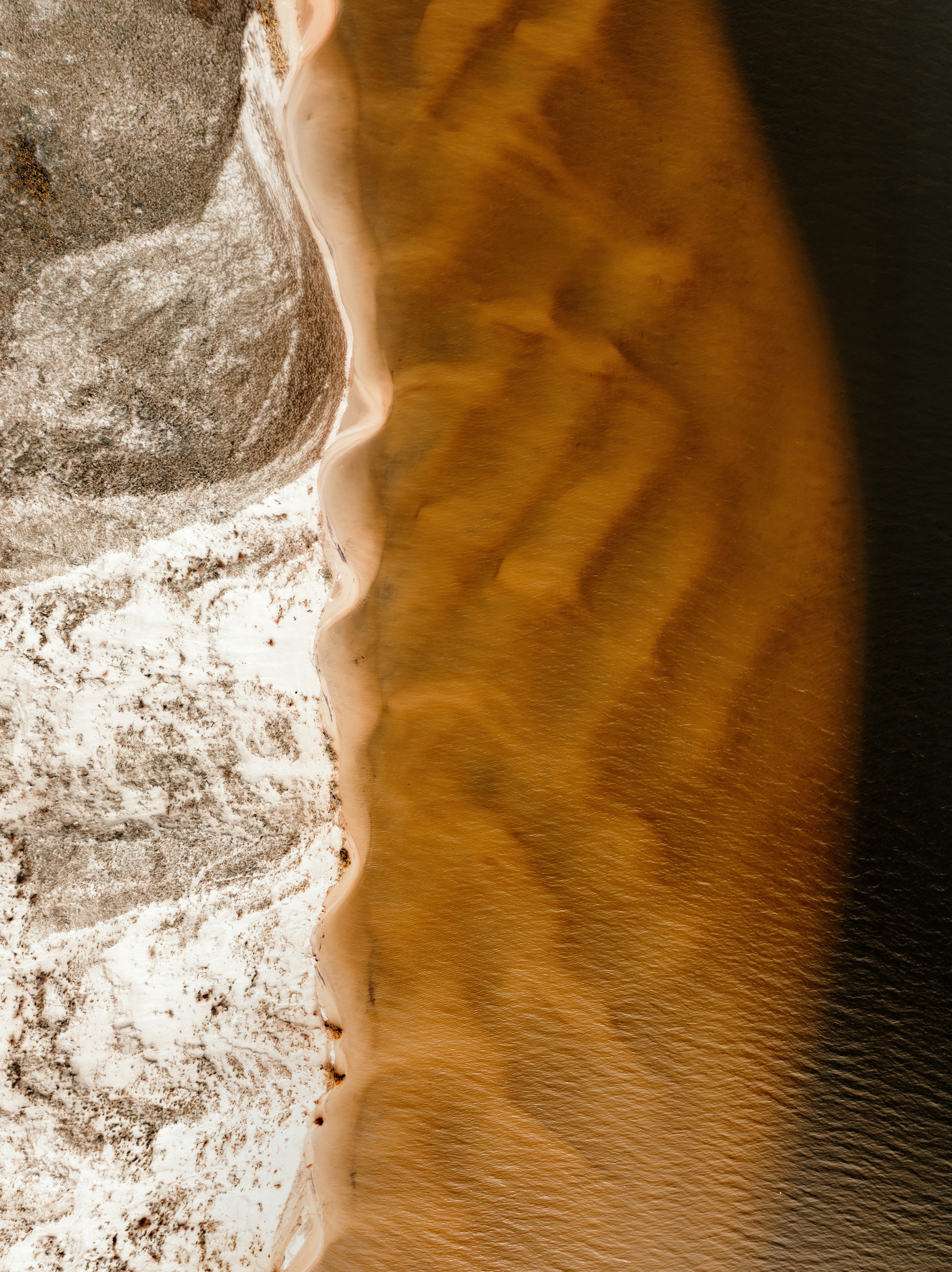 Aerial view of sandbar and dark water
