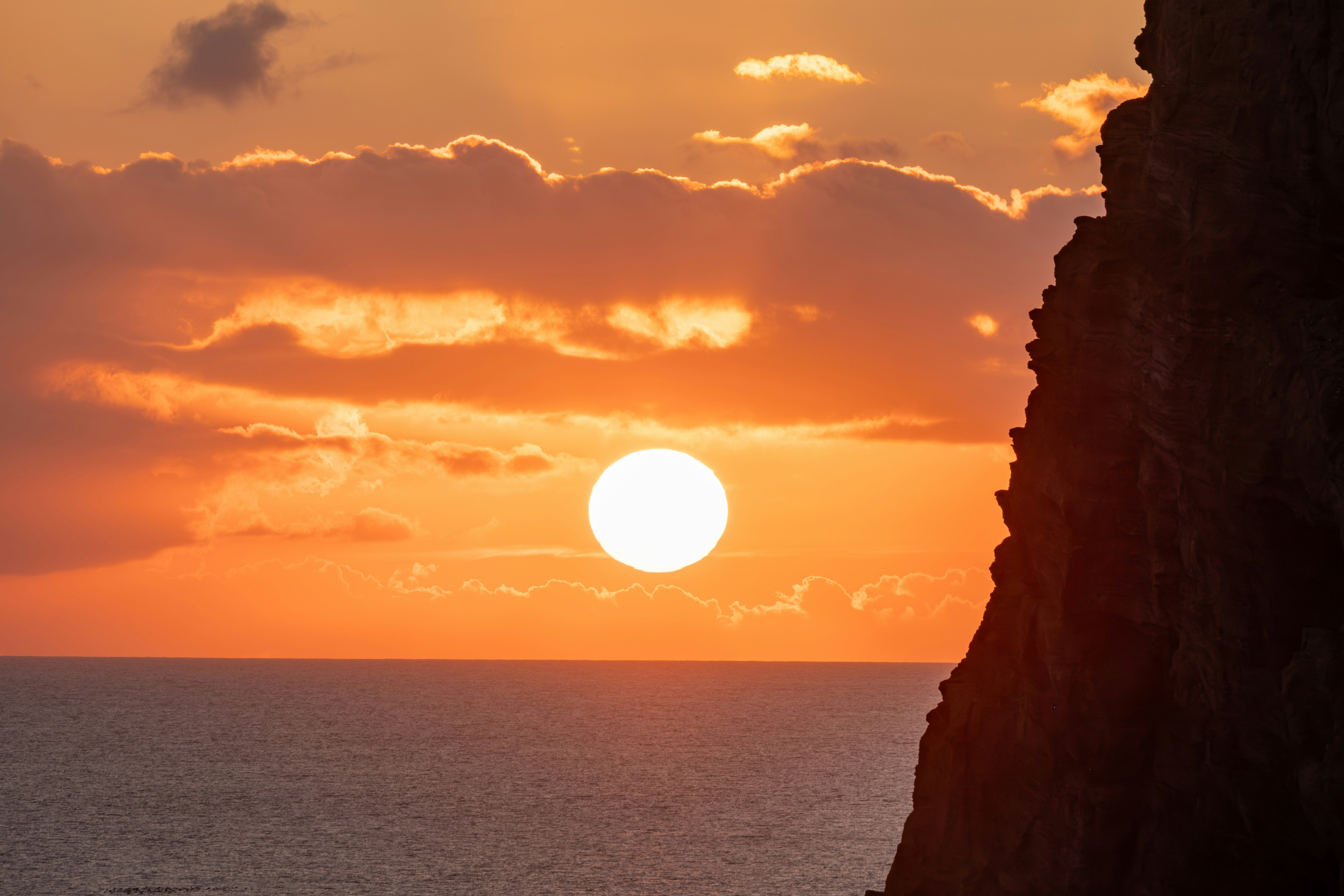 구름과 구름이 있는 바다 위로 지는 석양