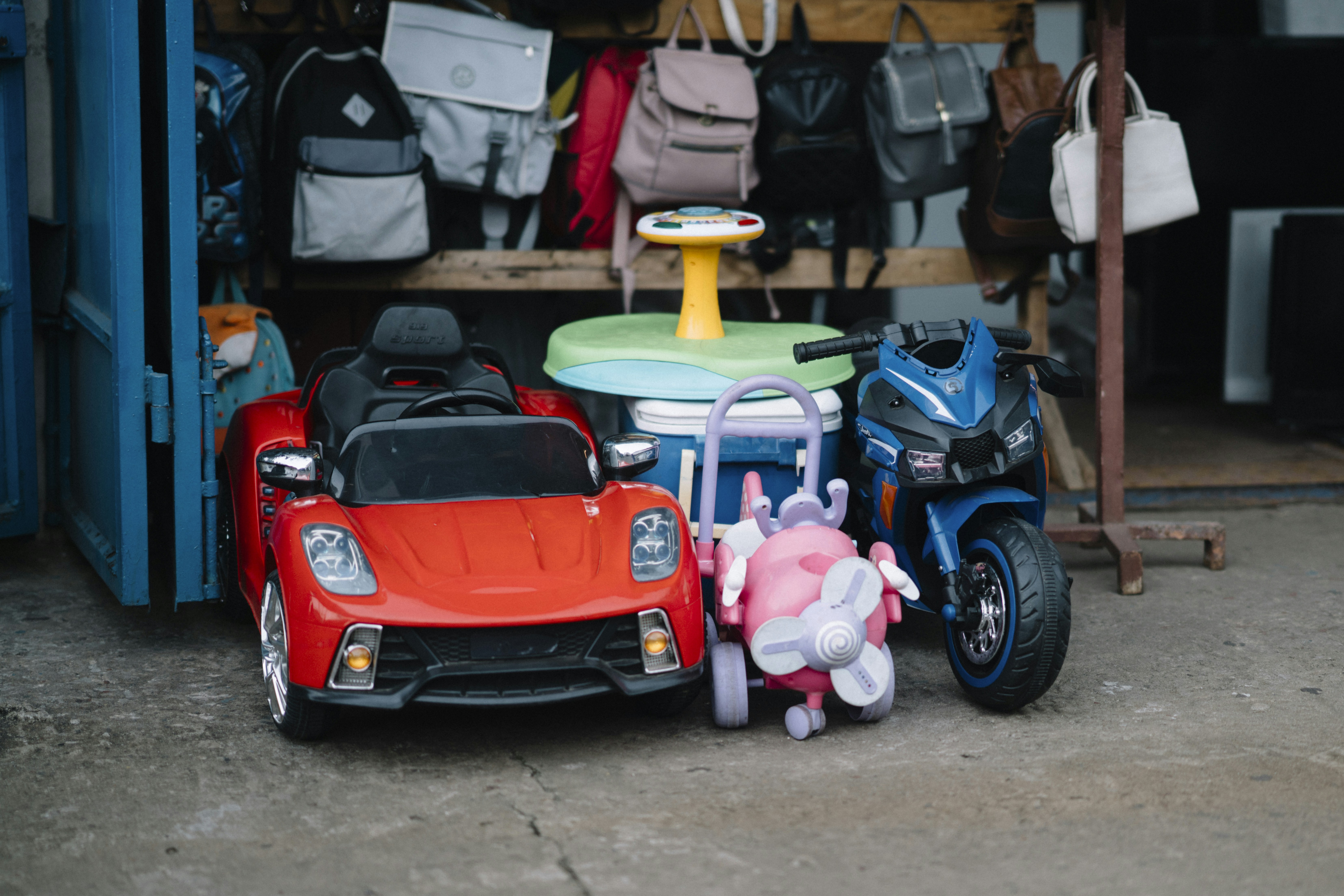 Children's ride-on toys and backpacks displayed bags