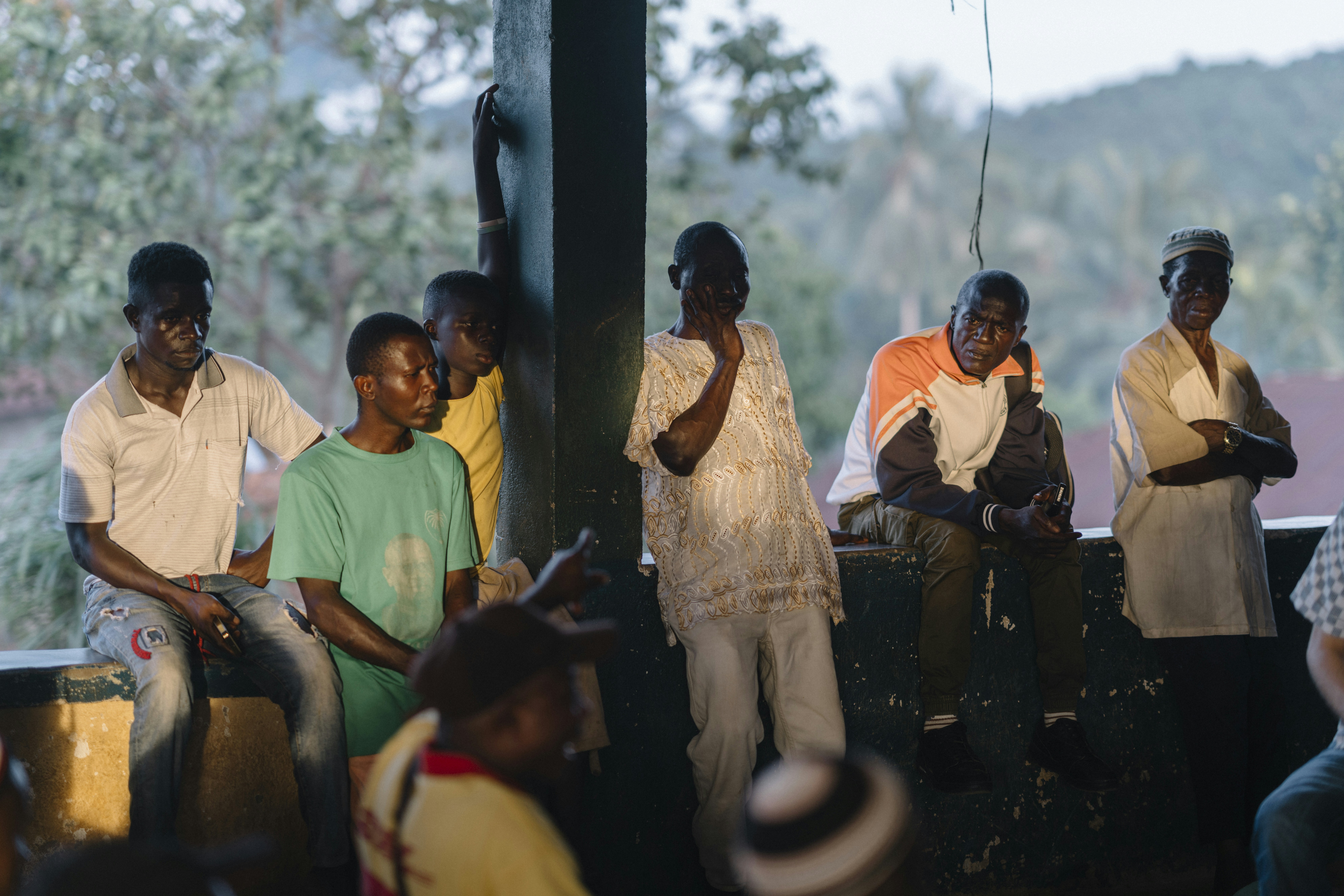 Group of men gathered outdoors, looking towards the viewer.