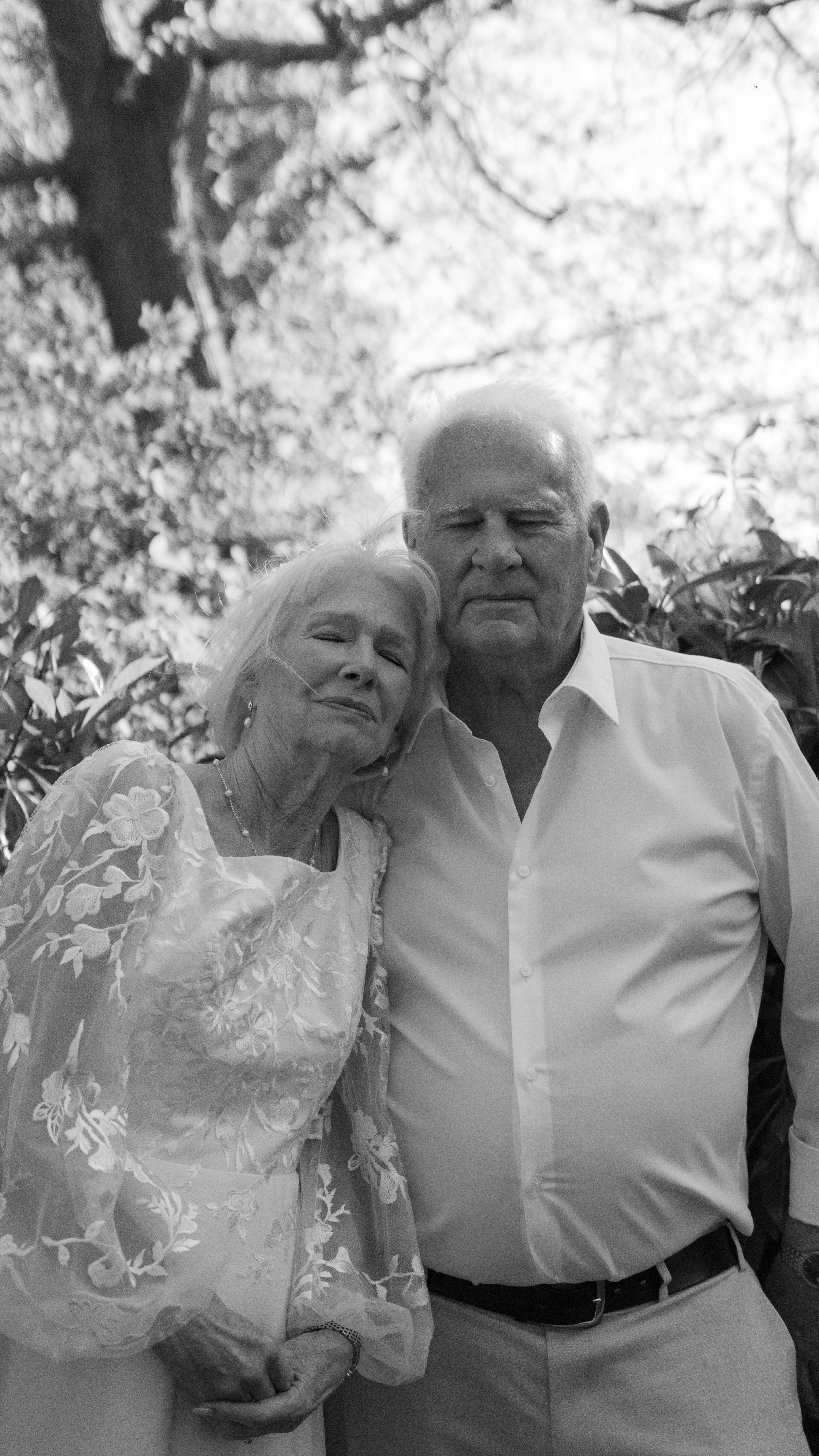 Couple de personnes âgées embrassant l’extérieur avec des arbres en arrière-plan